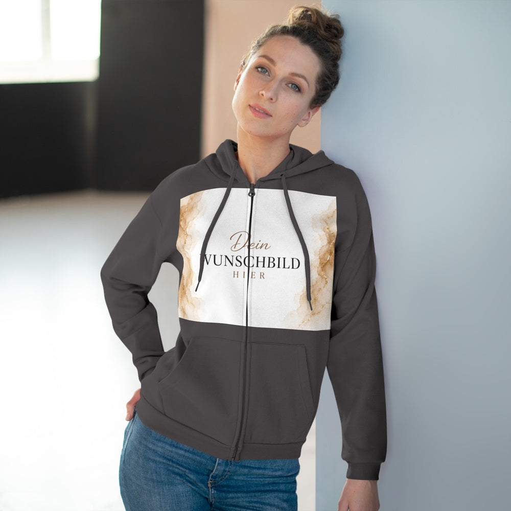 Frau trägt einen anthrazitfarbenen Zip-Hoodie mit personalisierbarem Wunschbild in einem modernen Innenbereich.