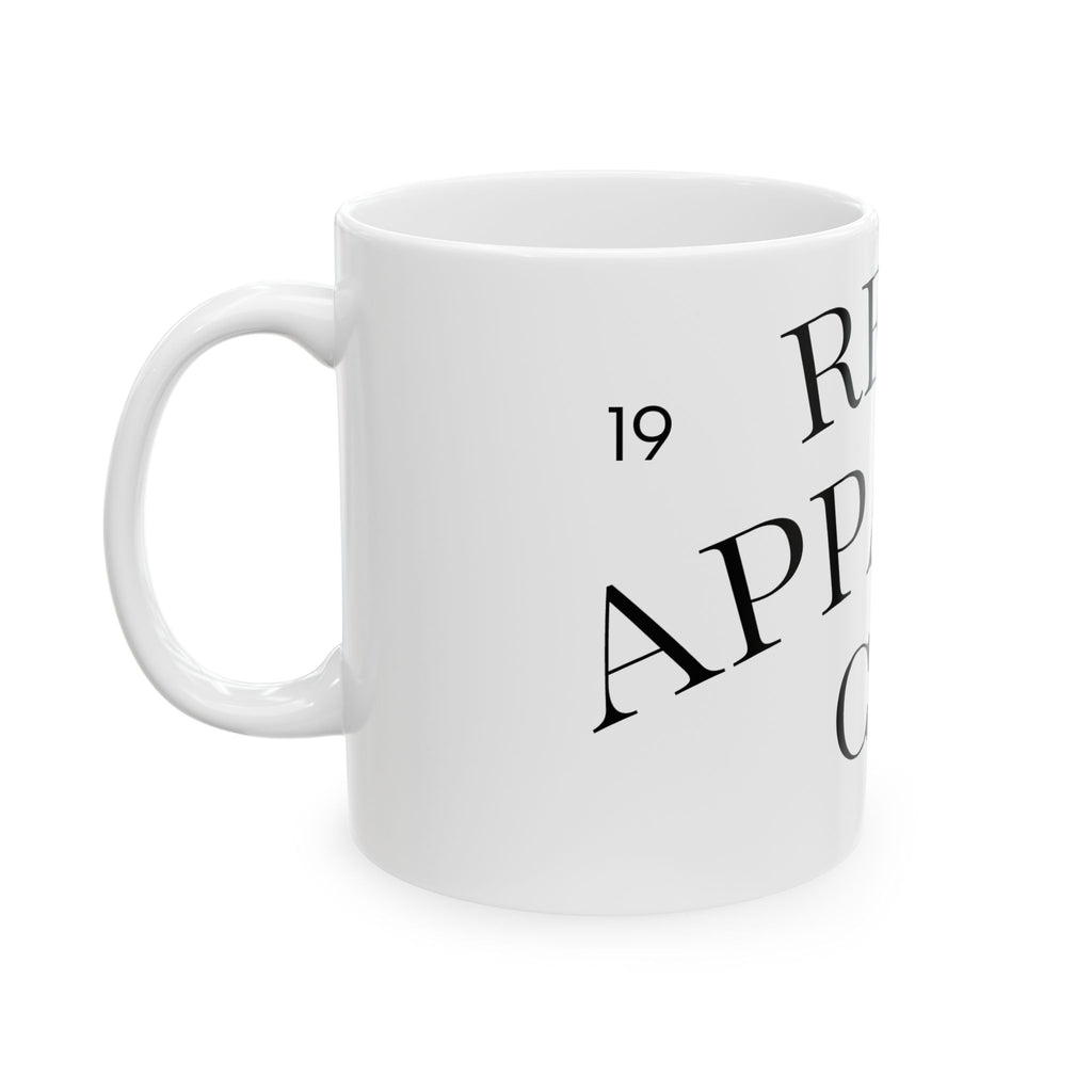 Weiße Kaffeetasse aus Keramik mit minimalistischem Schriftzug Real Apparel Co. und Jahreszahl 19
