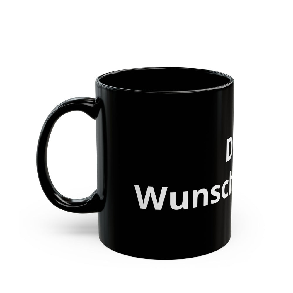 Schwarze Keramiktasse mit Wunschtext auf dekorativem Wintertisch mit heißem Getränk und gemütlichem Ambiente.